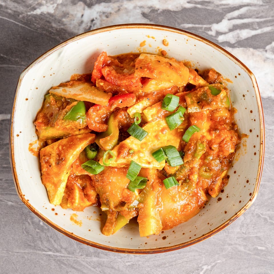 Chili Paneer from India's Best Curry & Grill, garnished with green onions in a white bowl.